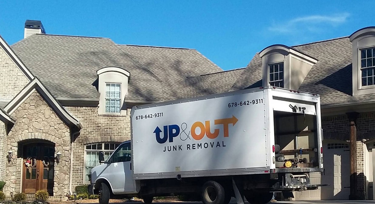Up & Out Junk Removal branded box truck parked at a residential driveway in Hiram, GA